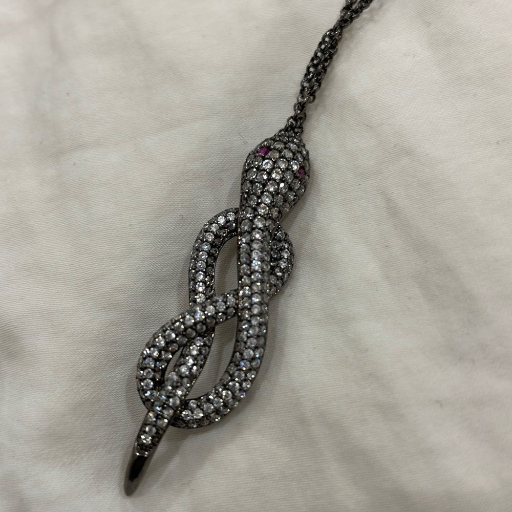 Snake necklace with faux diamonds red eyes making a figure 8 shape dark silver